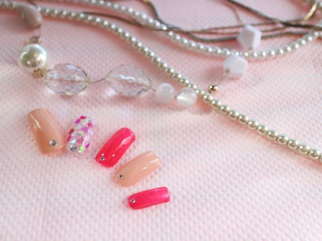 ピンクのネイルチップとパールのアクセサリー